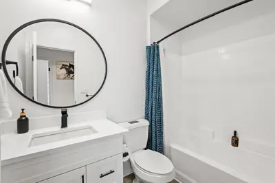 a white bathroom with a sink and a mirror at Charming 3BR Apartment | Near Disney + Arcade in Placentia