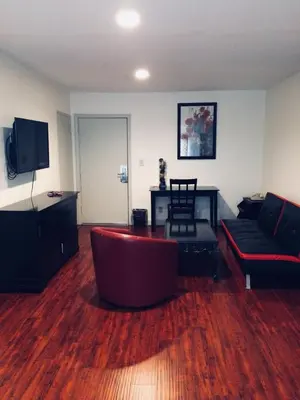 a living room with a couch and a table at Akua Inn & Suites - Anaheim - Fullerton in Anaheim