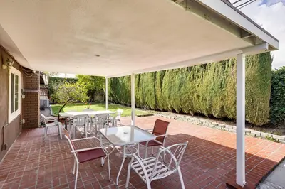 acovered patio with tables and chairs and a wall ofgrass at 5 Mi to Anaheim Convention Center Retreat with Yard in Anaheim