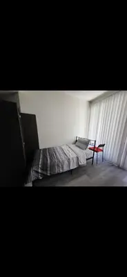 a bedroom with a bed and a table with a laptop on it at Shared but isolated room in a shared soace in Los Angeles
