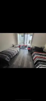 a room with two beds and a large window at Shared but isolated room in a shared soace in Los Angeles