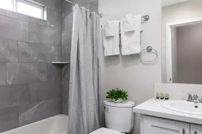 a white bathroom with a toilet and a sink at Relax in Spacious 4BR Home Sleeps 8 with Parking in North Hollywood