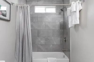 a bathroom with a white tub and a shower at Relax in Spacious 4BR Home Sleeps 8 with Parking in North Hollywood