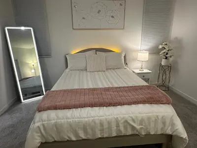 a bedroom with a large bed and a mirror at Ali's home in Fontana