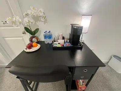 a black table with a coffee maker and a plate of fruit at Ali's home in Fontana