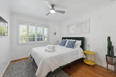 a white bedroom with a bed with towels on it at Heated Pool Oasis Close to Attractions in Encino