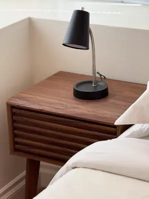 a lamp on a wooden table next to a bed at Modern Tarzana Poolside Retreat in Tarzana