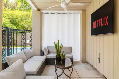 a living room with a couch and a table and a balcony at Modern Tarzana Poolside Retreat in Tarzana