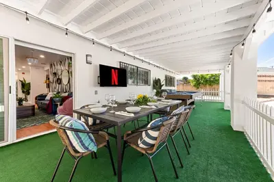 a patio with a table and chairs on a green floor at Stylish Getaway with Hot Tub in Northridge Hospital Heliport