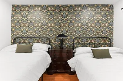 a bedroom with two beds and a wall with a wallpaper at Stylish Getaway with Hot Tub in Northridge Hospital Heliport