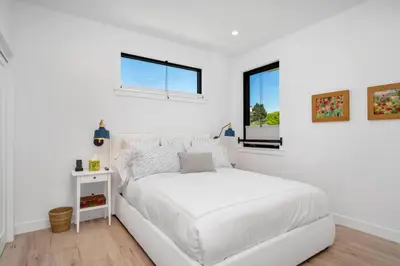 a white bedroom with a white bed and a window at NEW Venice Rose Ave Retreat with Sunset Deck in Los Angeles