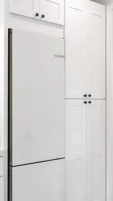 a white kitchen with a refrigerator and white cabinets at NEW Venice Rose Ave Retreat with Sunset Deck in Los Angeles