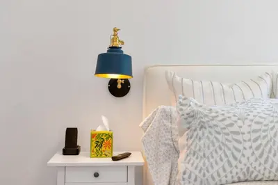 a bed with a blue lamp next to a side table at NEW Venice Rose Ave Retreat with Sunset Deck in Los Angeles