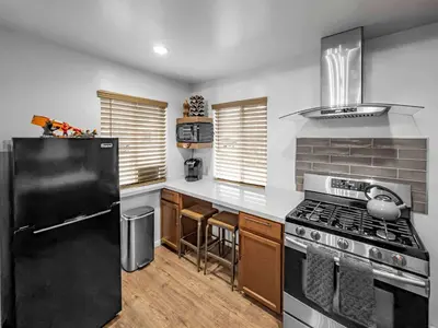 a kitchen with a black refrigerator and a stove at Mountain Deer Cabin W Foosball & Fenced Backyard in Big Bear City
