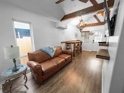 a living room with a leather couch and a table at Mountain Deer Cabin W Foosball & Fenced Backyard in Big Bear City