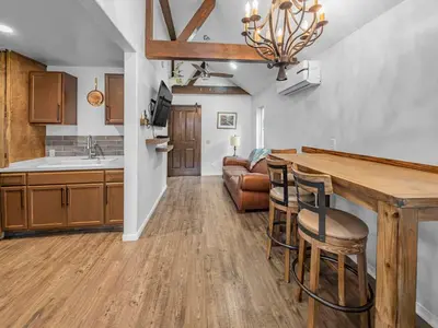 a kitchen with a table and chairs and a couch at Mountain Deer Cabin W Foosball & Fenced Backyard in Big Bear City