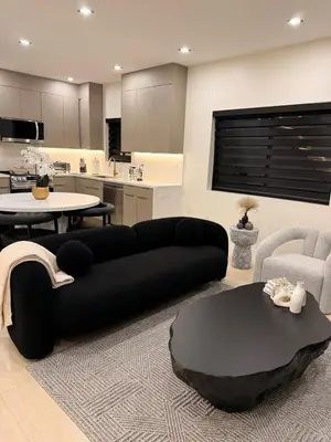 a living room with a black couch and a table at SkyLoft in Woodland Hills