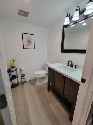 a bathroom with a sink and a toilet and a mirror at Spacious 2-Bedroom, One and a Half Bath Home in Pico-Robertson Near Beverly Hills and Cedars-Sinai in Los Angeles
