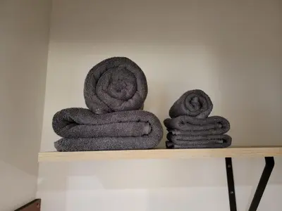 a pile of towels sitting on a shelf at Spacious 2-Bedroom, One and a Half Bath Home in Pico-Robertson Near Beverly Hills and Cedars-Sinai in Los Angeles