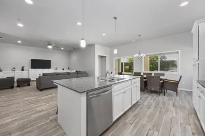 a kitchen and living room with a couch and a table at Spacious Home with Private Pool in Bakersfield