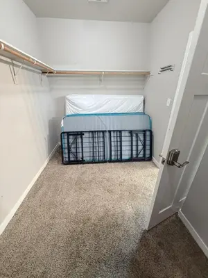 a small closet with a bed and a door at Spacious Home with Private Pool in Bakersfield