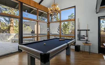 a pool table in a room with large windows at Beautiful Wrightwood Chalet in Wrightwood