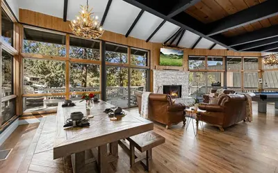 a living room with a table and a fireplace at Beautiful Wrightwood Chalet in Wrightwood