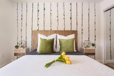 a bedroom with a bed with a flower on it at Stylish Home Prime Location with Fireplace & Patio in Los Angeles