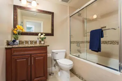 a bathroom with a toilet and a shower and a mirror at Stylish Home Prime Location with Fireplace & Patio in Los Angeles
