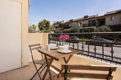 a wooden table and two chairs on a balcony at Stylish Home Prime Location with Fireplace & Patio in Los Angeles
