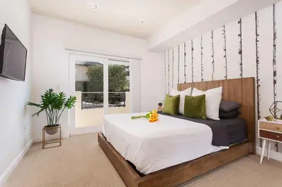 a bedroom with a large bed and a television at Stylish Home Prime Location with Fireplace & Patio in Los Angeles