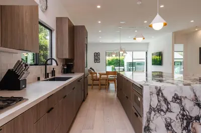 a kitchen with wooden cabinets and a counter top at Modern Poolside Paradise in Sherman Oaks
