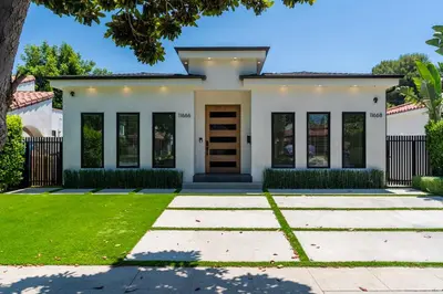 a white house with a brown door at Modern Poolside Paradise in Sherman Oaks