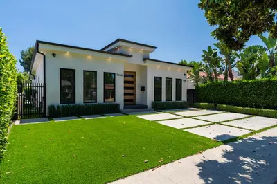 a house with a green lawn in front of it at Modern Poolside Paradise in Sherman Oaks
