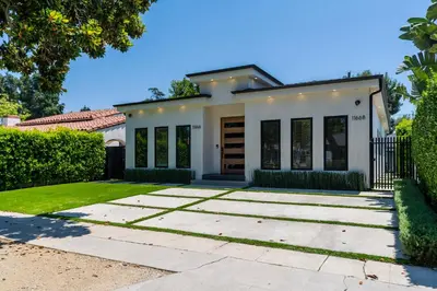 a white house with a driveway and grass at Modern Poolside Paradise in Sherman Oaks