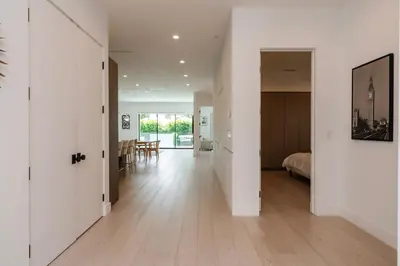 an open hallway with white walls and wood floors at Modern Poolside Paradise in Sherman Oaks
