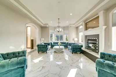 a living room with blue couches and a fireplace at Expansive Riverside Mansion! Luxe, Family Friendly in Riverside