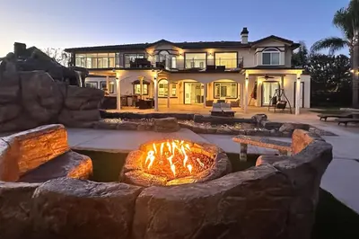 a large house with a fire pit in the yard at Expansive Riverside Mansion! Luxe, Family Friendly in Riverside