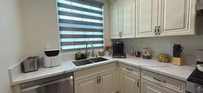 a kitchen with white cabinets and a sink and a window at Luxurious Pasadena Home w Parking & Near Old Town in Pasadena