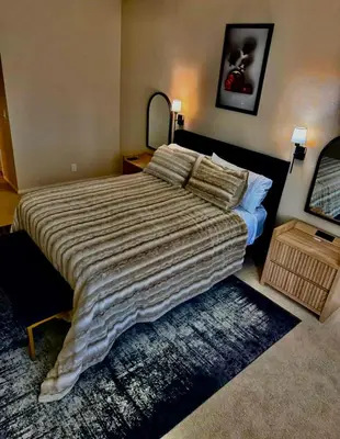 a bedroom with a large bed with a striped comforter at The Luxe Marina HideAway in Los Angeles