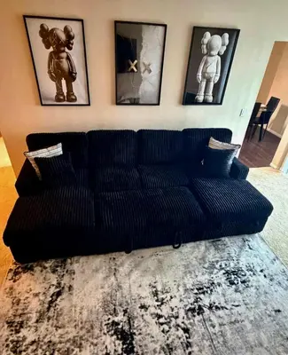 a black couch in a living room with pictures on the wall at The Luxe Marina HideAway in Los Angeles