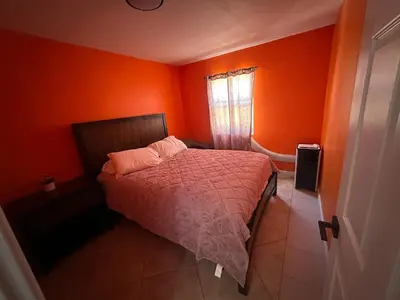 a bedroom with orange walls and a bed and a window at Desert Oasis Retreat in Barstow in Barstow