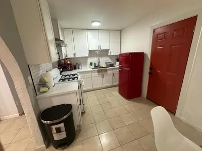 a kitchen with a red refrigerator and white cabinets at Desert Oasis Retreat in Barstow in Barstow