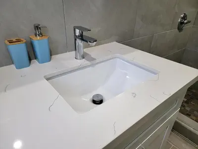 a white sink in a bathroom with two trash cans at Modern 2BR Guest Suite w En-Suite Bathrooms 10 min to Rodeo Drive Near Kaiser and Cedars hospitals in Los Angeles