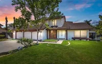 a house with a bench in a yard at 5 bedroom home 2 miles from Loma Linda Medical in Loma Linda
