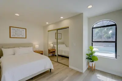 a bedroom with a white bed and a mirror at 5 bedroom home 2 miles from Loma Linda Medical in Loma Linda