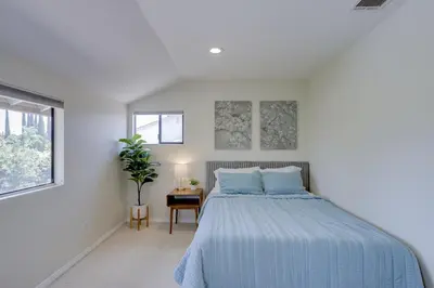 a white bedroom with a bed and a table at 5 bedroom home 2 miles from Loma Linda Medical in Loma Linda