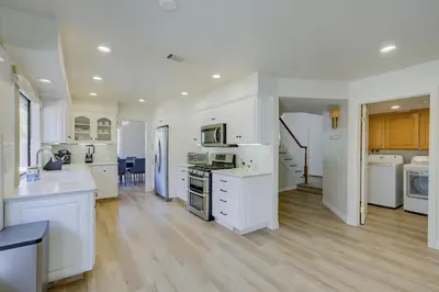 a large kitchen with white appliances and wooden floors at 5 bedroom home 2 miles from Loma Linda Medical in Loma Linda