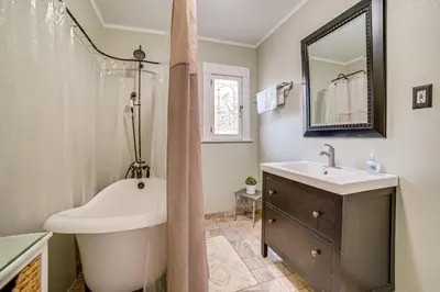 a bathroom with a tub and a sink and a mirror at Home half Mi to Dtwn Riverside Families Welcome! in Riverside