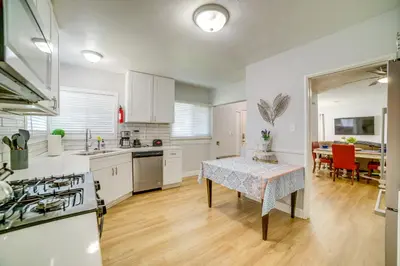 a kitchen with white cabinets and a table and a dining room at Family-Friendly Home 2 Mi to Dtwn Riverside in Riverside